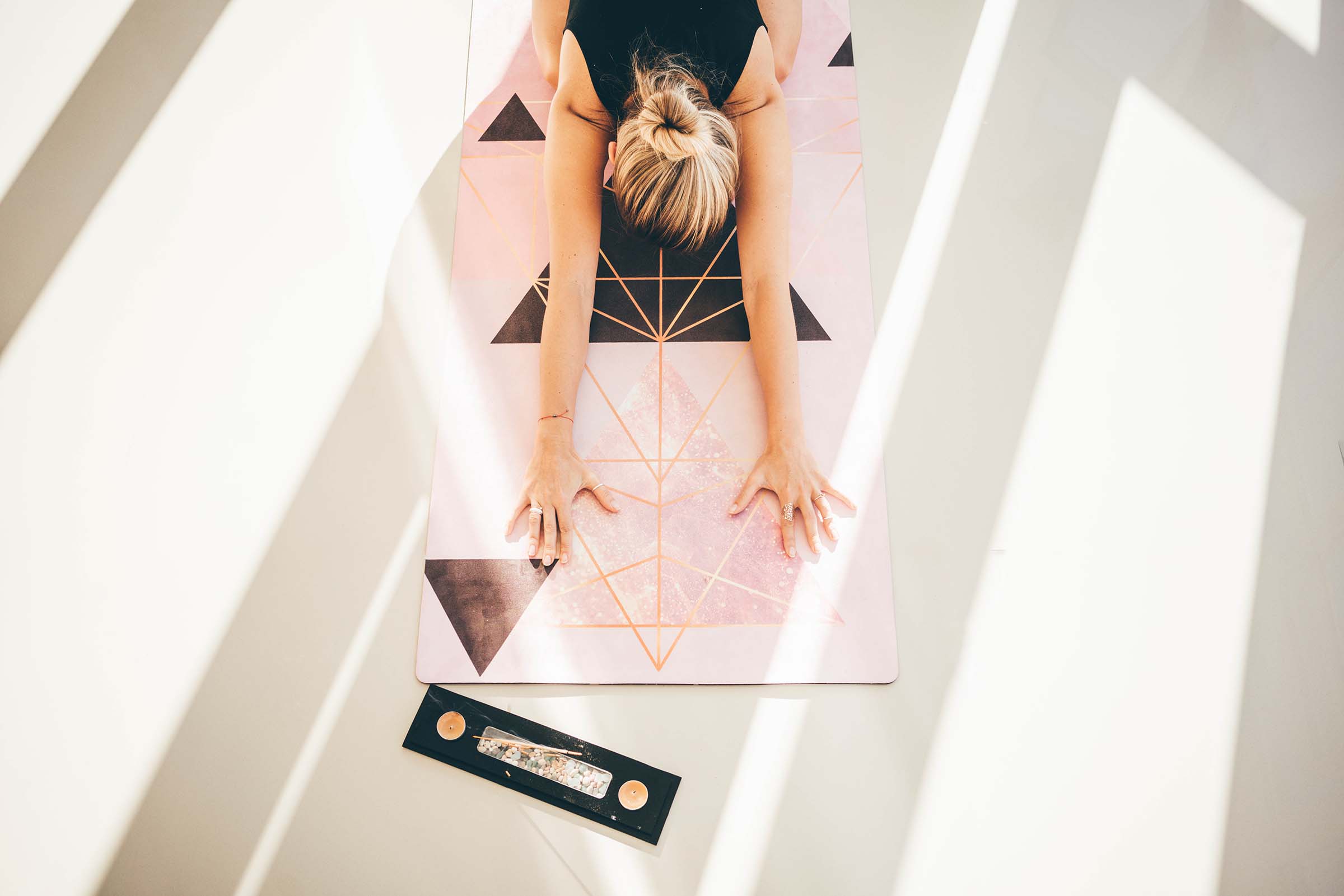 Woman practising yoga on a patterned mat at home